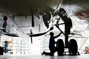 Technician working on landing gear of commercial aircraft in the hangar